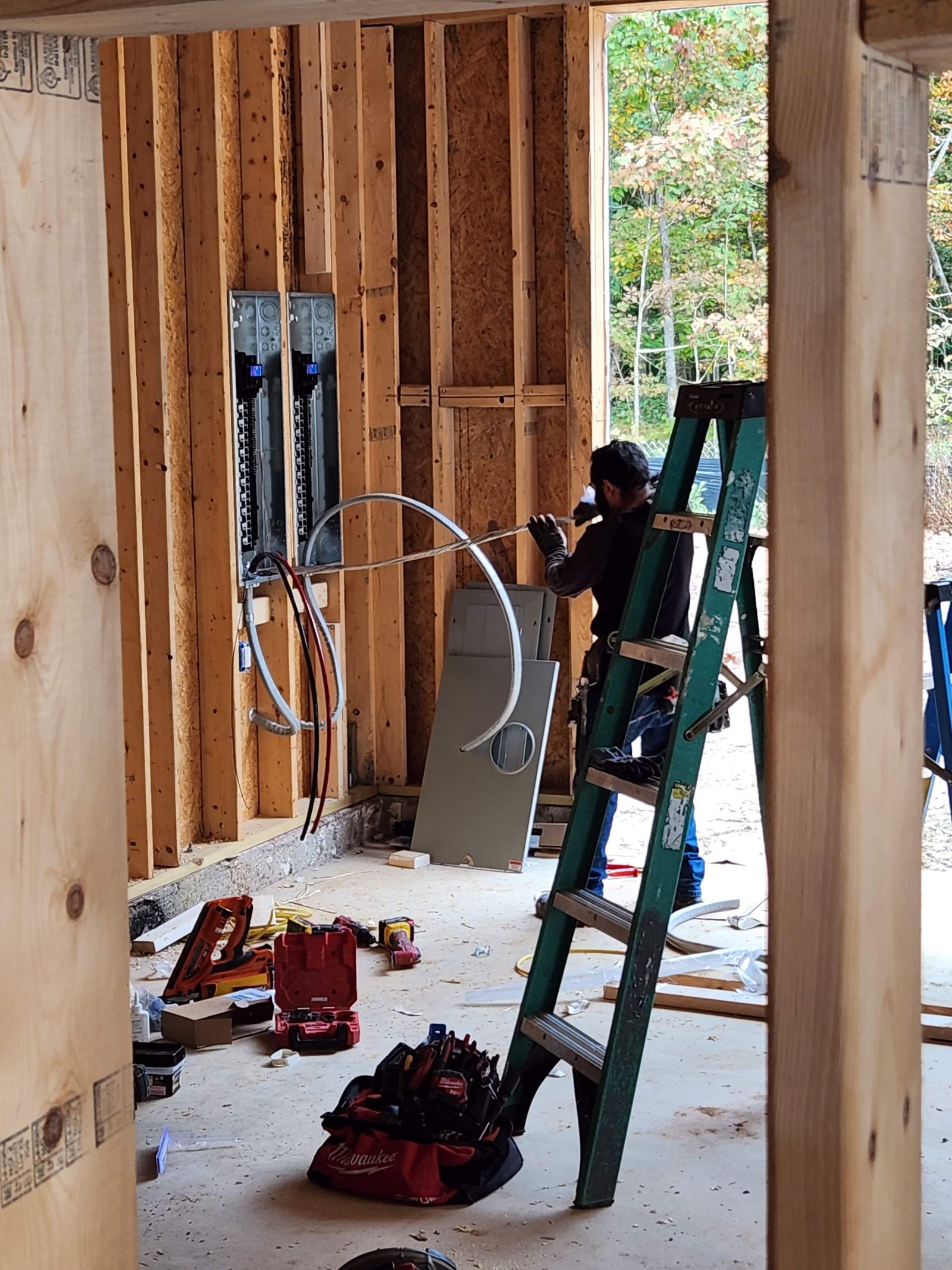 Electrical rough-in and panel installation within framed walls