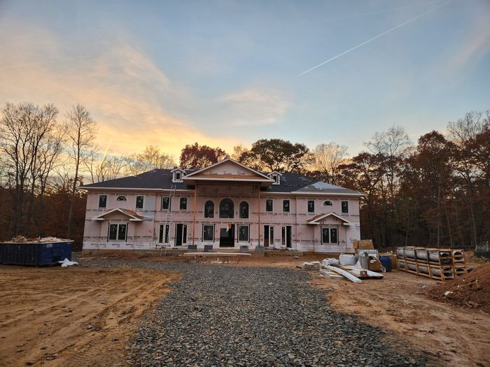 Residence at exterior finishing stage with roofing and windows complete