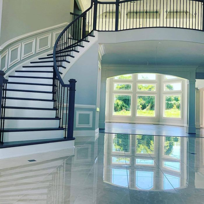 Completed entry hall with double staircase and polished stone flooring