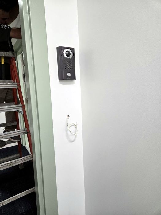 Intercom module installation in progress, device face redacted